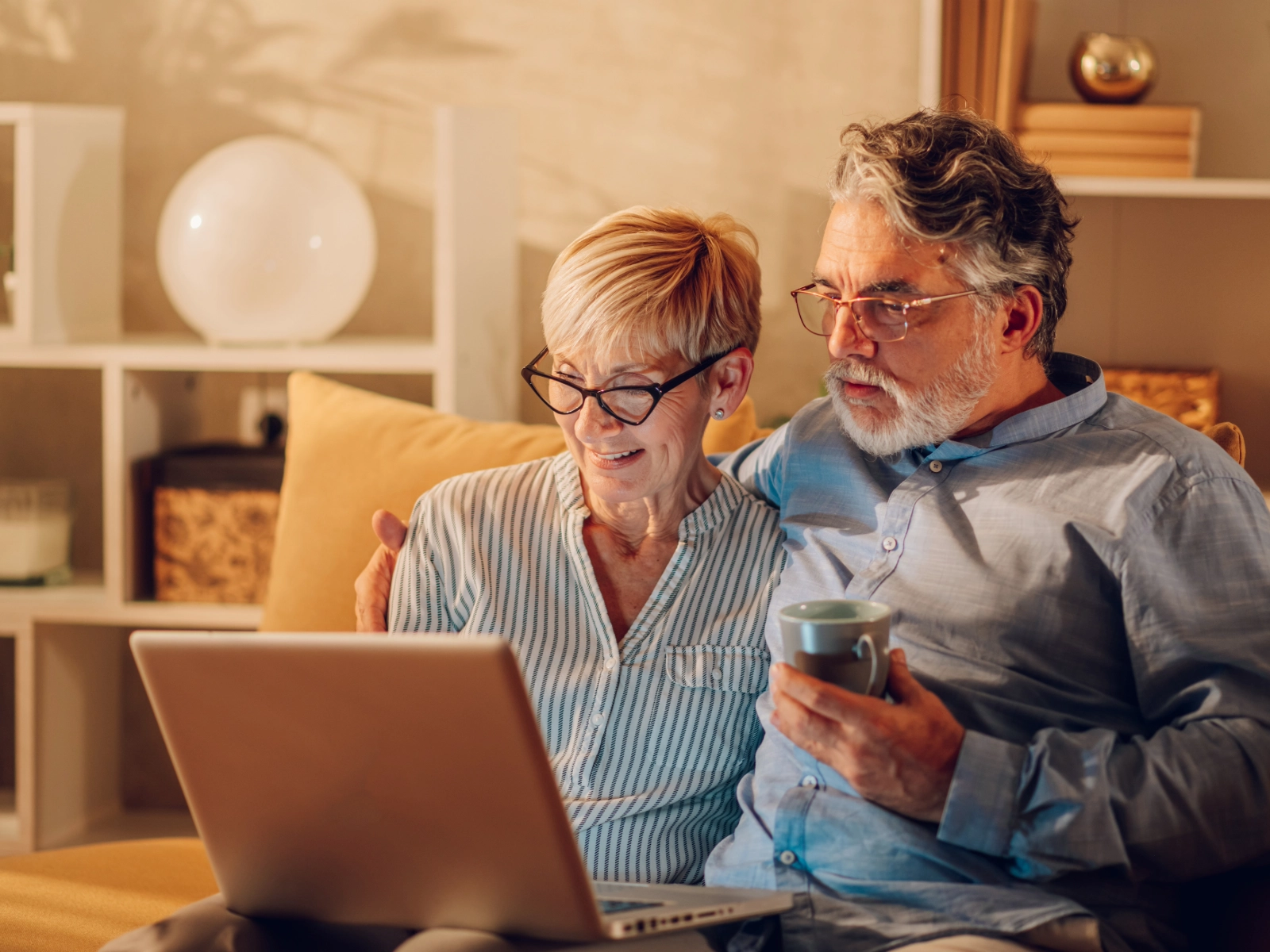 Zwei Personen sitzen auf der Couch und schauen auf einen Laptop